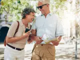 Mature happy couple on holiday with a map