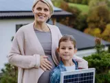 Pregnant woman with daughter holding a solar panel