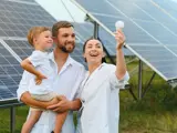 Happy family in front of solar panels